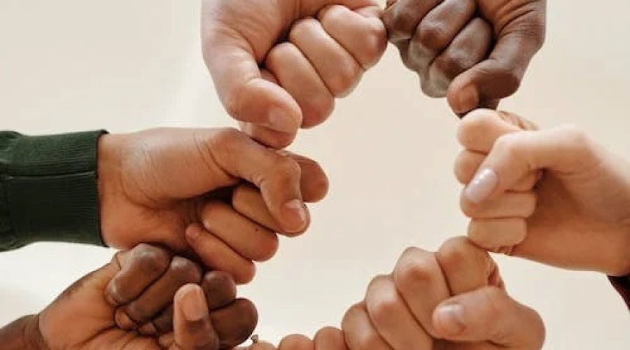 Mans de persones de races diferents simbolitzant la cooperació