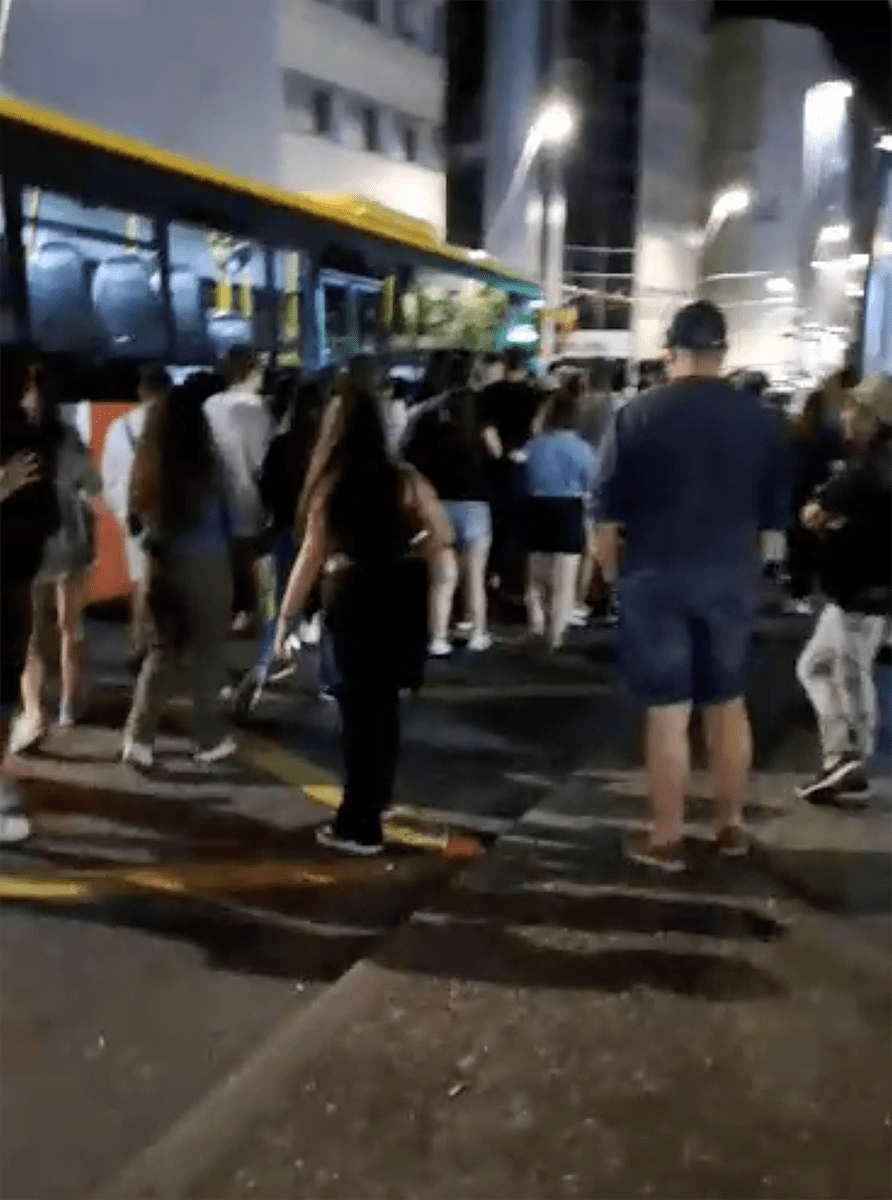 Joves intentant accedir a un autobús nocturn en el marc de la Festa Major laurediana.